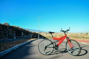 a red bike is parked on the road photo