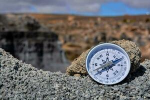 a compass on a rock in the middle of a desert photo