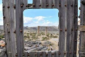 un antiguo de madera puerta en el Desierto con un ver de el montañas foto