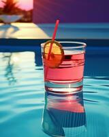 Pink cocktail with lemon wedge sitting on the pool table photo