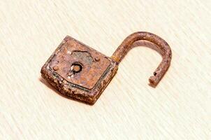 old rusty padlock on wooden surface photo