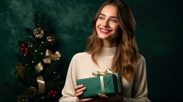Beautiful girl standing on a green background with a gift in the hands photo