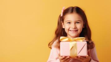 hermosa niña en pie en un rosado antecedentes con un regalo en el manos foto