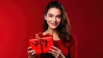 hermosa niña en pie en un rojo antecedentes con un regalo en el manos foto