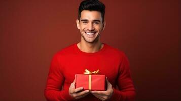 Beautiful girl standing on a red background with a gift in the hands photo