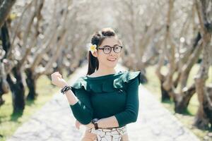 Portrait of asian women standing inside the Plumeria tunnel in front of Nan national museum of Nan province of Thailand. photo