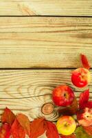 collection beautiful colorful autumn leaves and apples on wooden background. photo