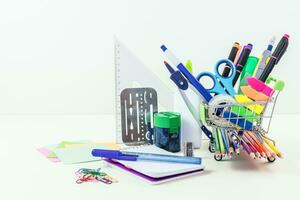 Shopping cart with school supplies. Back to school. Online shopping. photo