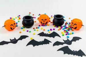 Halloween, pumpkins, bat silhouettes, spider web silhouette and paper spiders, on white background. Selective focus. photo