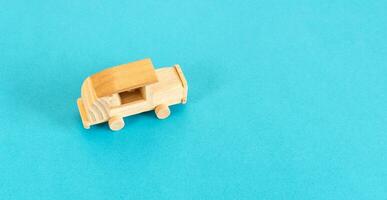 Wooden car toy isolated on blue background, top view. photo