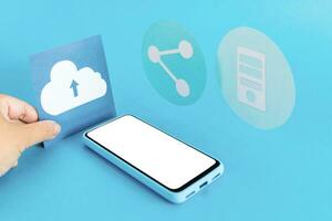 File storage in the cloud. Cloud storage concept. Icons and smart phone on light blue background. photo