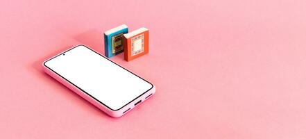 Isometric view of mobile phone and two books on pink background. Distance education. photo