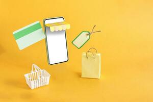 The shopping basket, credit card and bag floating out of the online store on a yellow background. photo