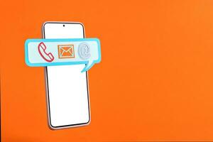 Smart phone and speech bubble with communication icons on orange background. photo