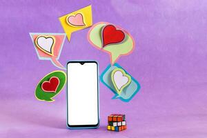 Mobile phone and dialogue bubbles with hearts. Dating app concept. photo