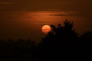 the sun sets behind a building in the background photo