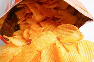 Potato chips in open bag, delicious BBQ seasoning spicy for crips, thin slice deep fried snack fast food. photo