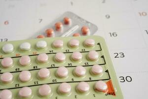 Birth control pills for female on calendar, ovulation day. photo