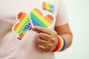 Asian woman with rainbow flag, LGBT symbol rights and gender equality, LGBT Pride Month in June. photo