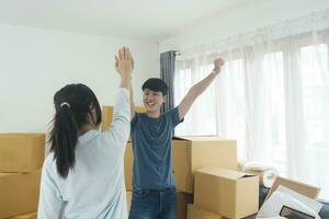 Happy couple with cardboard boxes in new house at moving day. photo