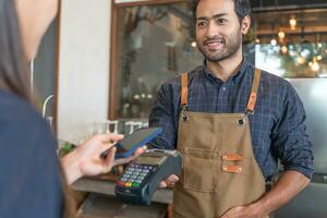 la mujer usa un teléfono inteligente para escanear el código qr para pagar en un café restaurante con un pago digital sin efectivo. elige menú y ordena acumula descuento. billetera electrónica, tecnología, pago en línea, tarjeta de crédito, aplicación bancaria. foto