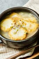 Korean fish cake soup served in a black clay pot photo