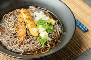 A summer dish of cold wheat noodles with fried shrimp in a black bowl photo