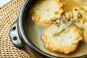 Korean fish cake soup served in a black clay pot photo