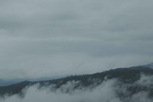 Beautiful panoramic view of fog and clouds in distant layers mountains range with blue sky in morning photo