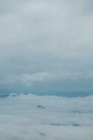 Mountain range with visible silhouettes through the morning blue fog. photo