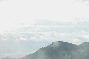 Mountain range with visible silhouettes through the morning blue fog. photo