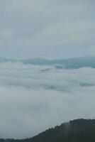 Mountain range with visible silhouettes through the morning blue fog. photo