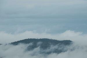 Mountain range with visible silhouettes through the morning blue fog. photo