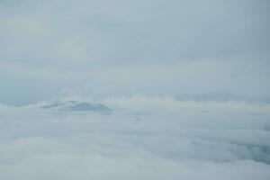 Mountain range with visible silhouettes through the morning blue fog. photo