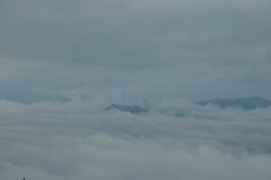 Mountain range with visible silhouettes through the morning blue fog. photo