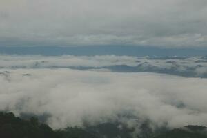 Mountain range with visible silhouettes through the morning blue fog. photo