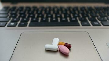 Various types of drugs, placed on a laptop keyboard photo