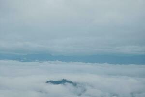 Mountain range with visible silhouettes through the morning blue fog. photo