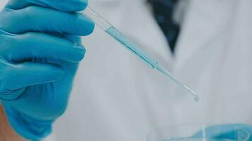 Medical or scientific researcher or man doctor looking at a test tube of clear solution in a laboratory video