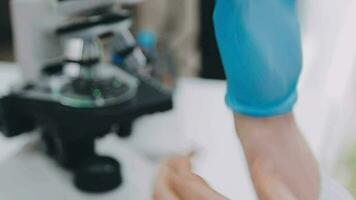 Medical or scientific researcher or man doctor looking at a test tube of clear solution in a laboratory video