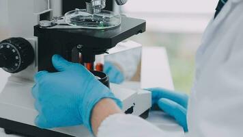 Medical or scientific researcher or man doctor looking at a test tube of clear solution in a laboratory video