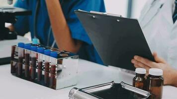 Medical or scientific researcher or man doctor looking at a test tube of clear solution in a laboratory video