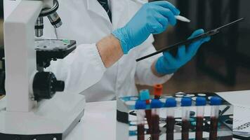 Medical or scientific researcher or man doctor looking at a test tube of clear solution in a laboratory video