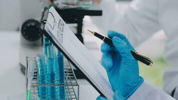 Medical or scientific researcher or man doctor looking at a test tube of clear solution in a laboratory video