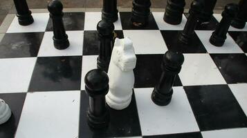 Big chess on giant chessboard in park outside. photo