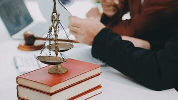 Business and lawyers discussing contract papers with brass scale on desk in office. Law, legal services, advice, justice and law concept picture with film grain effect video