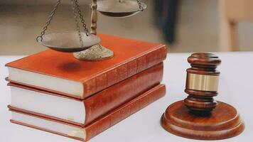 Business and lawyers discussing contract papers with brass scale on desk in office. Law, legal services, advice, justice and law concept picture with film grain effect video