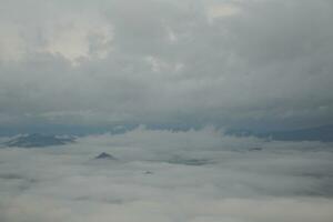 Mountain range with visible silhouettes through the morning blue fog. photo