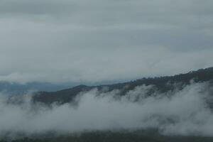 Beautiful panoramic view of fog and clouds in distant layers mountains range with blue sky in morning photo