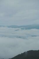 Mountain range with visible silhouettes through the morning blue fog. photo